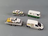 four toy cars and a truck on a gray surface