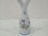 a white vase with a blue and yellow design on it