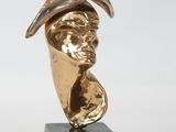 bronze bust of a woman wearing a hat on a marble base