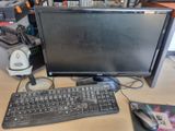 a computer monitor, keyboard and mouse on a desk