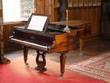 un piano à queue dans une pièce aux murs lambrissés