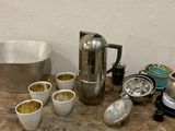 a lot of coffee pots and cups sitting on a table