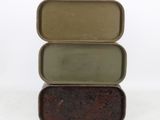 three tins stacked on top of each other on a white surface