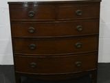 une commode en bois dans une pièce aux murs de briques blanches