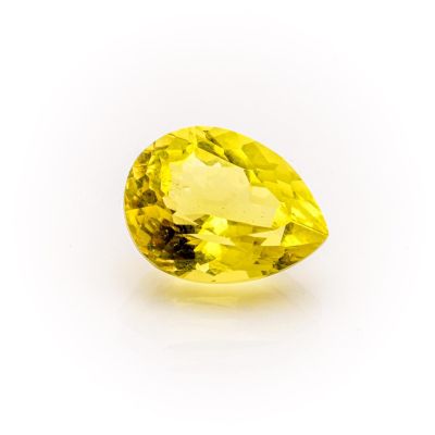a close up of a yellow sapphire stone on a white surface