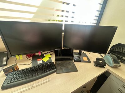 un bureau sur lequel se trouvent deux écrans d'ordinateur et un ordinateur portable
