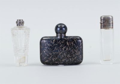 trois flacons de parfum posés l'un à côté de l'autre sur une surface blanche