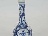a small blue and white vase on a white surface