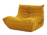 Le grand fauteuil jaune est posé sur une surface blanche