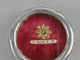 a close up of a red box with a gold flower on it