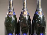 trois bouteilles de champagne posées côte à côte sur une table