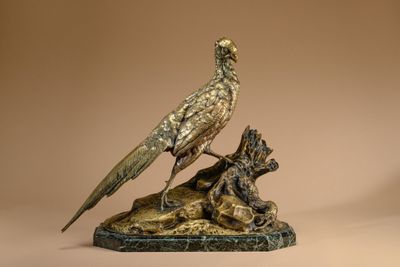 statue of a bird on a rock with a dog on it