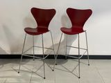 deux chaises rouges posées sur un sol carrelé, près d'un mur blanc