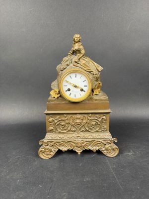 une horloge en or surmontée d'une statue