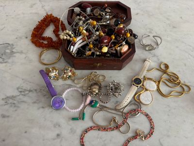 une boîte en bois remplie de bijoux variés, posée sur une table