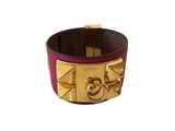 leather cuff bracelet with gold plated metal details on a white background