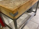 une table en bois sur laquelle est posé un couteau, dans une cuisine