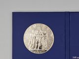 an image of a blue book with a silver coin on it