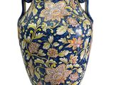 un vase muni d'une anse ornée d'un motif floral