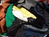 a pile of clothes sitting on top of a suitcase