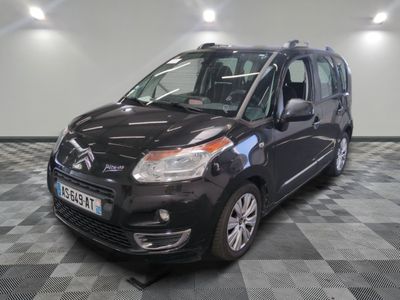 La petite camionnette noire est garée sur un sol en damier.