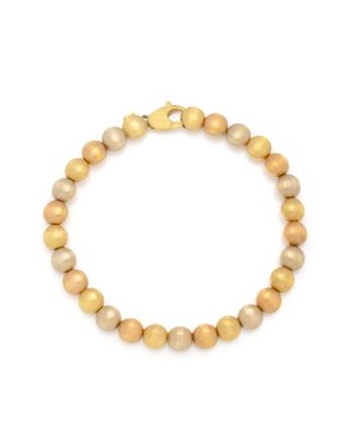 a gold beaded bracelet on a white background