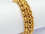 a close up of a gold bracelet on top of a napkin