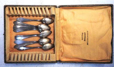 six cuillères dans une boîte posée sur une table