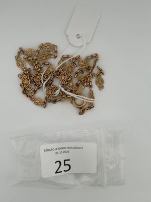 a bag of gold chains and a tag on a table