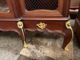 a wooden cabinet with a glass door and gold handles