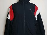 La veste est noire, rouge et blanche, avec une rayure rouge et blanche.