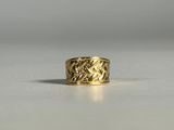 gros plan d'une bague en or sur une surface blanche