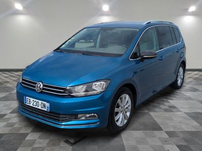 the blue volkswagen touran is parked in a room with a checkered floor