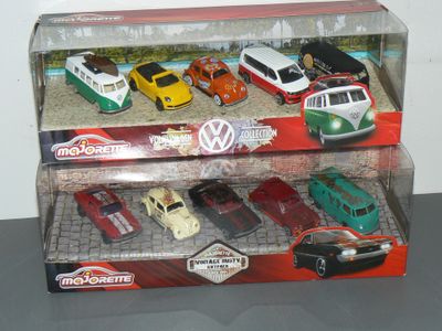 les petites voitures sont exposées dans une vitrine posée sur une table