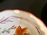 une assiette décorée d'une fleur, posée sur une table
