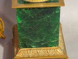 a green vase with a gold base and a gold base on it