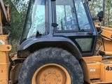 a yellow tractor that is parked in the dirt