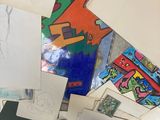 a person standing in front of a pile of drawings