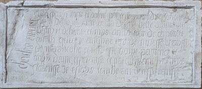 plaque on the side of a building with writing on it
