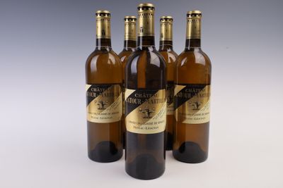 four bottles of wine are lined up in a row on a table