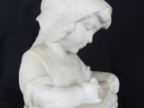 marble statue of a child reading a book on a black background