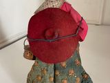 a figurine of a woman with a red hat and green dress