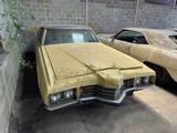 two old cars parked next to each other in a garage