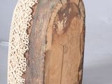a piece of wood with a lace on top of it