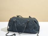le sac matelassé noir est posé sur une table blanche