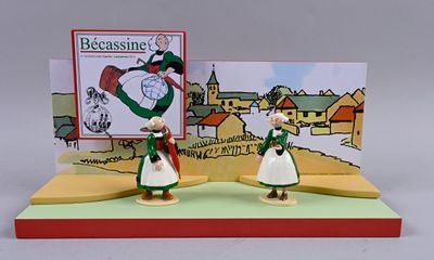 two figurines of people standing in front of a christmas card