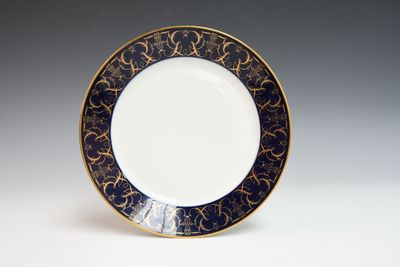 une image représentant une assiette bleue et dorée posée sur une surface blanche
