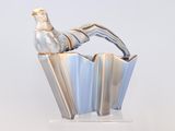 un vase en argent surmonté d'un oiseau