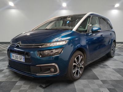 a blue citrole parked on a checkered floor in a garage