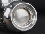 a silver tea pot on a black table